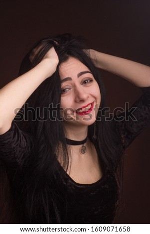 brunette on dark background dressed in goth style