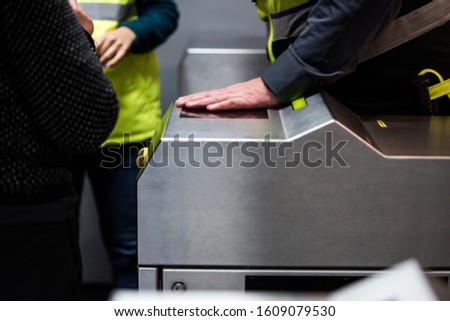 Security guard in subway station. Guard checking an automatic ticket machine at a metro station.