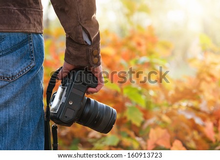 Photographer holding camera outdoors