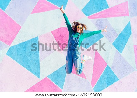 Woman jumping in front of a colorful background