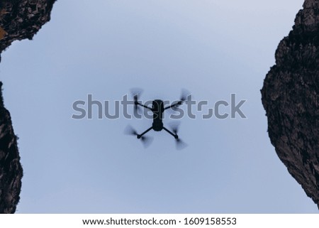 silhouette of a quadcopter flying in the sky against the background of the Caucasus Mountains