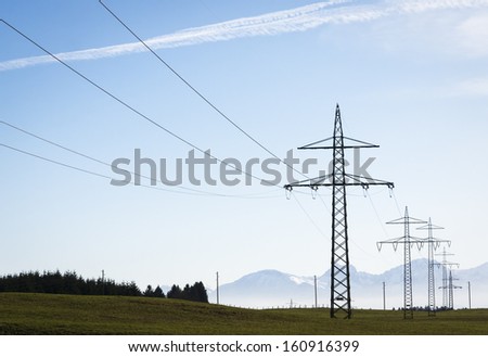 electricity pylons in front of blue sky