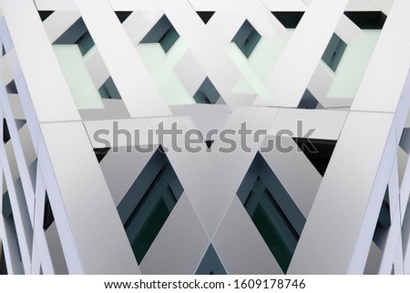 Double exposure photo of concrete facade resembling constructivist or futuristic building with complex structure of facade. Modern office architecture. Angular pattern of polygons and parallel lines.
