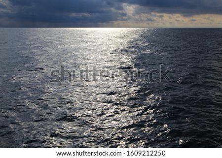 Clear water texture in blue. Background of the ocean and the sea backlit by the sun. Natural water