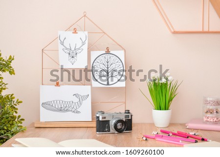 Stylish comfortable workplace with moodboard and photo camera in modern room