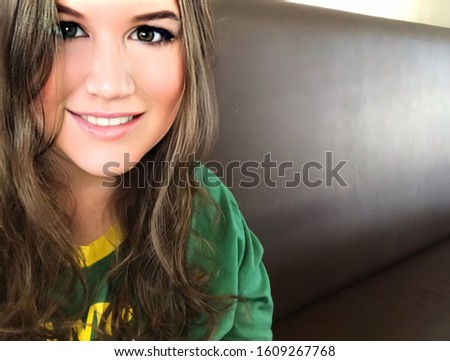 Selfie of a woman. Self portrait of a Caucasian woman in a cafe/restaurant alone. Selfie of a Caucasian woman smiling with a bench in the background.