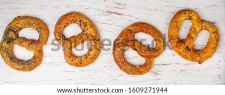 Pretzel. A set of different pretzels with black and white sesame, poppy seeds, cumin or caraway, large sea salt on a marble table. Sweet and salty appetizer. German (Bavarian) beer appetizer. banner