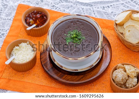 Bean stock served with pork rinds, grated cheese, toast and pepper.