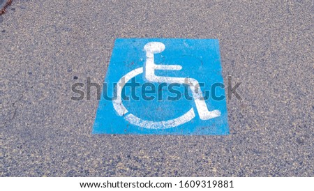 Panorama frame Handicapped icon painted on tarmac on a cloudy day