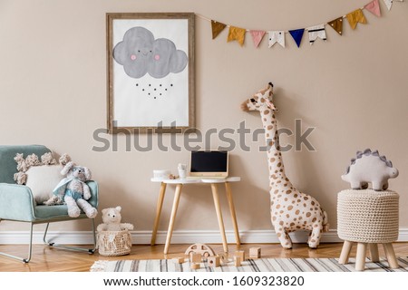 Stylish and beige scandinavian decor of kid room with mock up poster frame,  design furnitures, natural toys, hanging colorful flags, plush animal and child accessories and teddy bears. Home decor. Royalty-Free Stock Photo #1609323820