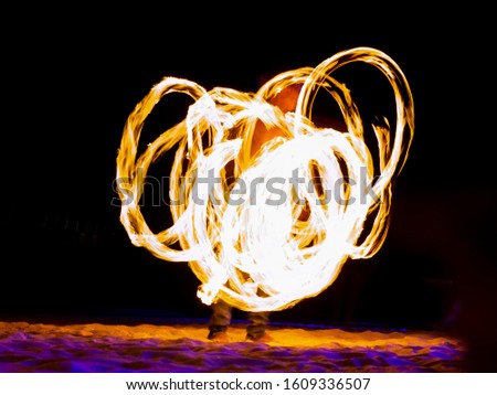 Koh Tao,Thailand,January 5,2020:Fire juggling performance and long exposure picture of a street artist form tails.