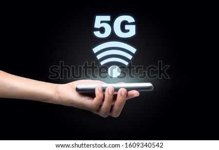 Hand of a business man holding a smartphone with 5 G wireless high speed Internet, Technology concept Royalty-Free Stock Photo #1609340542
