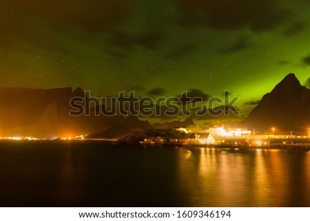 northern lights, Polar lights with many clouds and stars on the sky over autumn and mountains in the North of Europe in the autumn , Lofoten islands, Norway, long shutter speed.