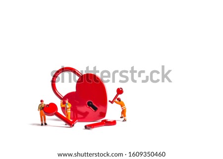 miniature workers with heart shape padlock isolated on white background.