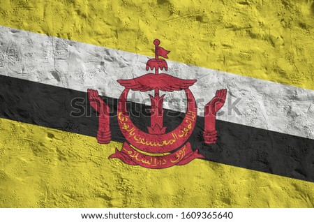 Brunei Darussalam flag depicted in bright paint colors on old relief plastering wall. Textured banner on rough background