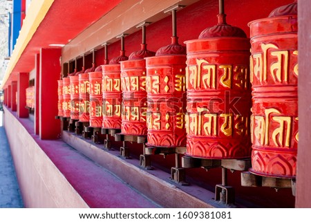 Picture of prayer wheels in a row. Buddhist praying drums with mantras.