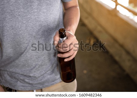 Portrait of a drunken man holding a bottle in front of him