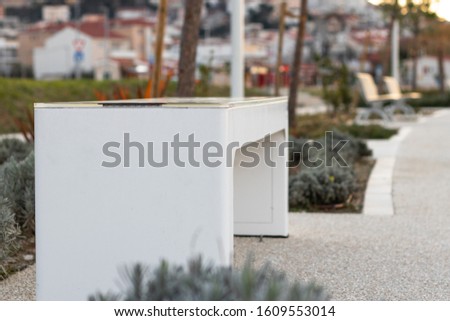 White smart bench in stobrec, croatia. Solar powered white sleek design with ports for charging smartphones. Royalty-Free Stock Photo #1609553014