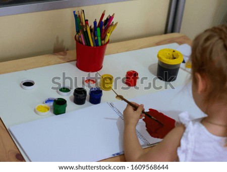 child paints in an album