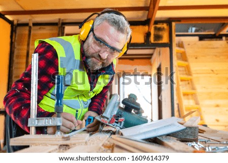 Man doing woodwork in carpentry. Carpenter work on wood plank in workshop.