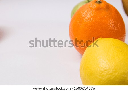 
fresh fruits close-up on a light background. orange, kiwi, apple, mandarin and lemon
