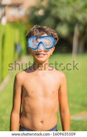 Smiling boy with snorkeling glasses on sunny day