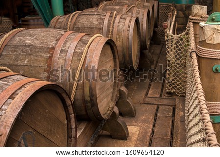 Old large wine wooden barrels on a wooden floor tied with a large rope.