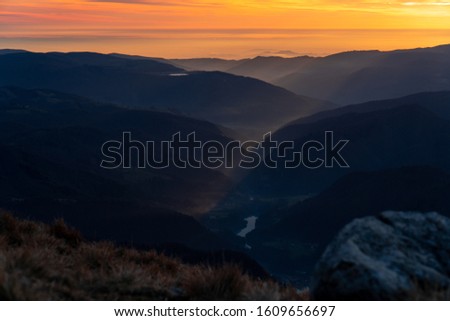 Winter clolourful sunset over mountains and river valley