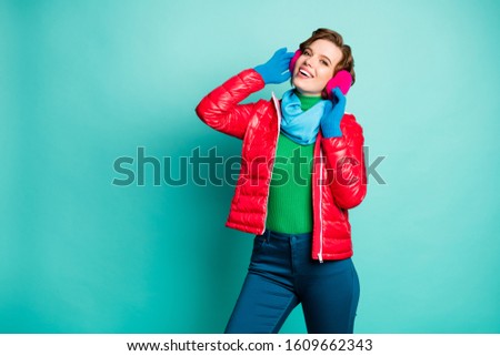 Photo of funny traveler lady enjoy sunny winter day skating spend free time rejoicing wear stylish casual red overcoat blue scarf pink ear covers trousers isolated teal color background
