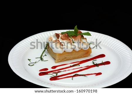 Cake with cream decorated with mint on a white paper platter