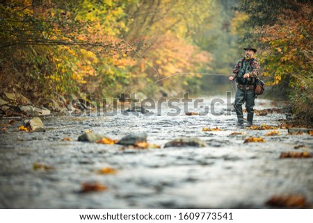 Fly fisherman fly fishing on a splendid mountain river Royalty-Free Stock Photo #1609773541