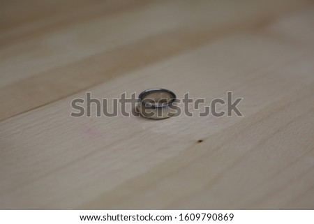 Sterling Silver wedding band on a wooden work table
