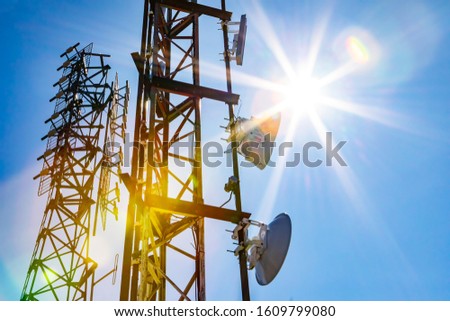 Electromagnetic radiation under the hot summer sun, colorful radioactive pollution concept with two cellular network towers and copy space to right Royalty-Free Stock Photo #1609799080