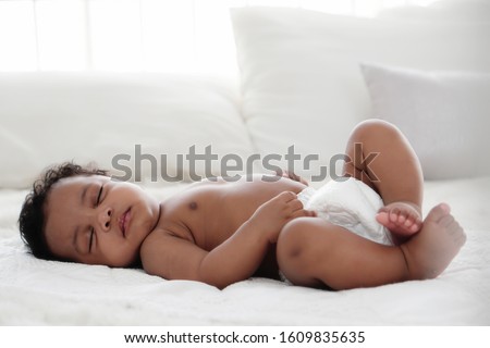 portrait of african american baby girl sleeping on white bed Royalty-Free Stock Photo #1609835635
