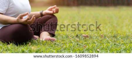 Closeup on hands. Asian Senior Woman in white shirt practicing Yoga at park. Meditation position with Copy space. Banner, Panoramic. BeH3althy