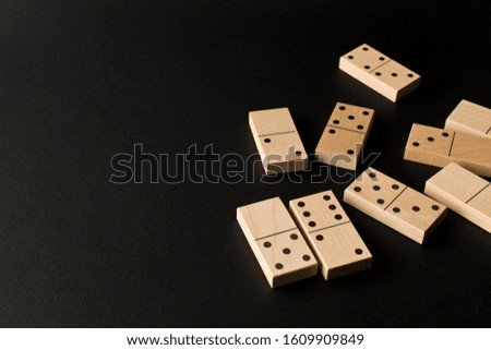 Playing dominoes on a dark background. Leisure games concept. Domino effect. Selective focus