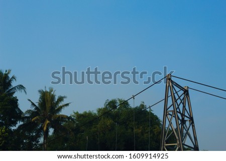Metal rope at floating bridge, Modern bridge pylon against a blue sky. suspension bridge in beams of the coming sun against the blue sky Royalty-Free Stock Photo #1609914925
