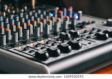 An analog Behringer Mixer with faders set and  lights onmixer Royalty-Free Stock Photo #1609920595