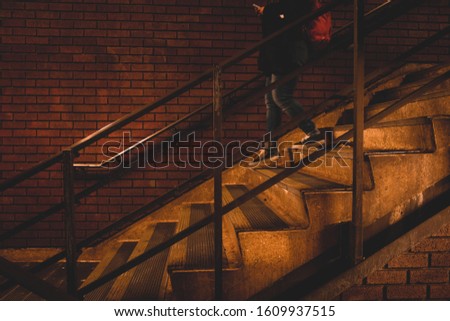 Brick wall man woman female male walking down to stairs subway city building