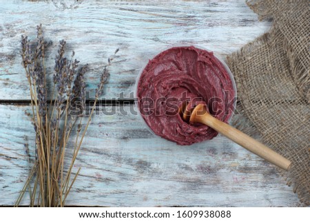 Whipped honey in deep burgundy color and a bunch of lavender flowers, top view
