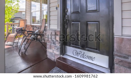 Panorama Front door of house with glass panes and porch with chairs railings and columns