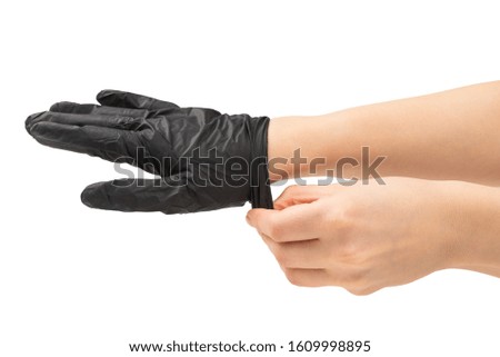 Woman puts on black rubber gloves. Isolated on white.