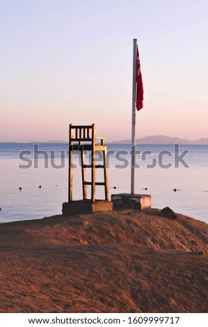 Lifeguard chair against the backdrop of the sea bay. Picture in purple colors.