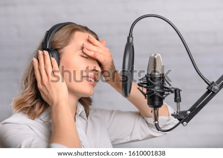 Girl works on the radio or the news. Reads the news in the studio. Radio station and broadcast. Emotional reading in the microphone.