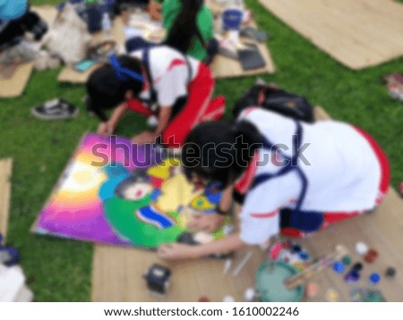 Blurred image of children drawing and painting.