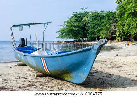 Boat on carib Coast colorful on beach Costa Rica puerto viejo de talamanca natural dirt  Royalty-Free Stock Photo #1610004775
