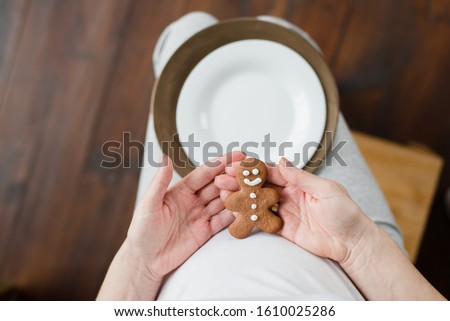 close up. Cropped photo of pregnant woman holding ginger cookies on belly. people and expectation concept. Happy motherhood, healthy life. expecting a child. Baby born in copyspace
