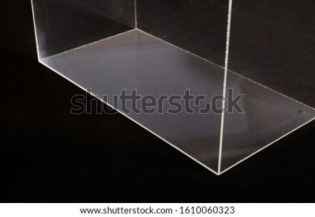 Transparent box made of organic glass stands on a black background
