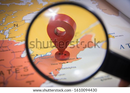 New York city in focus through magnify glass on United states of America map with a location GPS icon world map