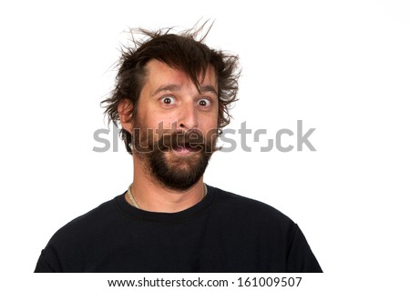 Goofy young man, with full beard and moustache and wild hair, pulling a comical face to the camera  Studio portrait over white  Space for your text 